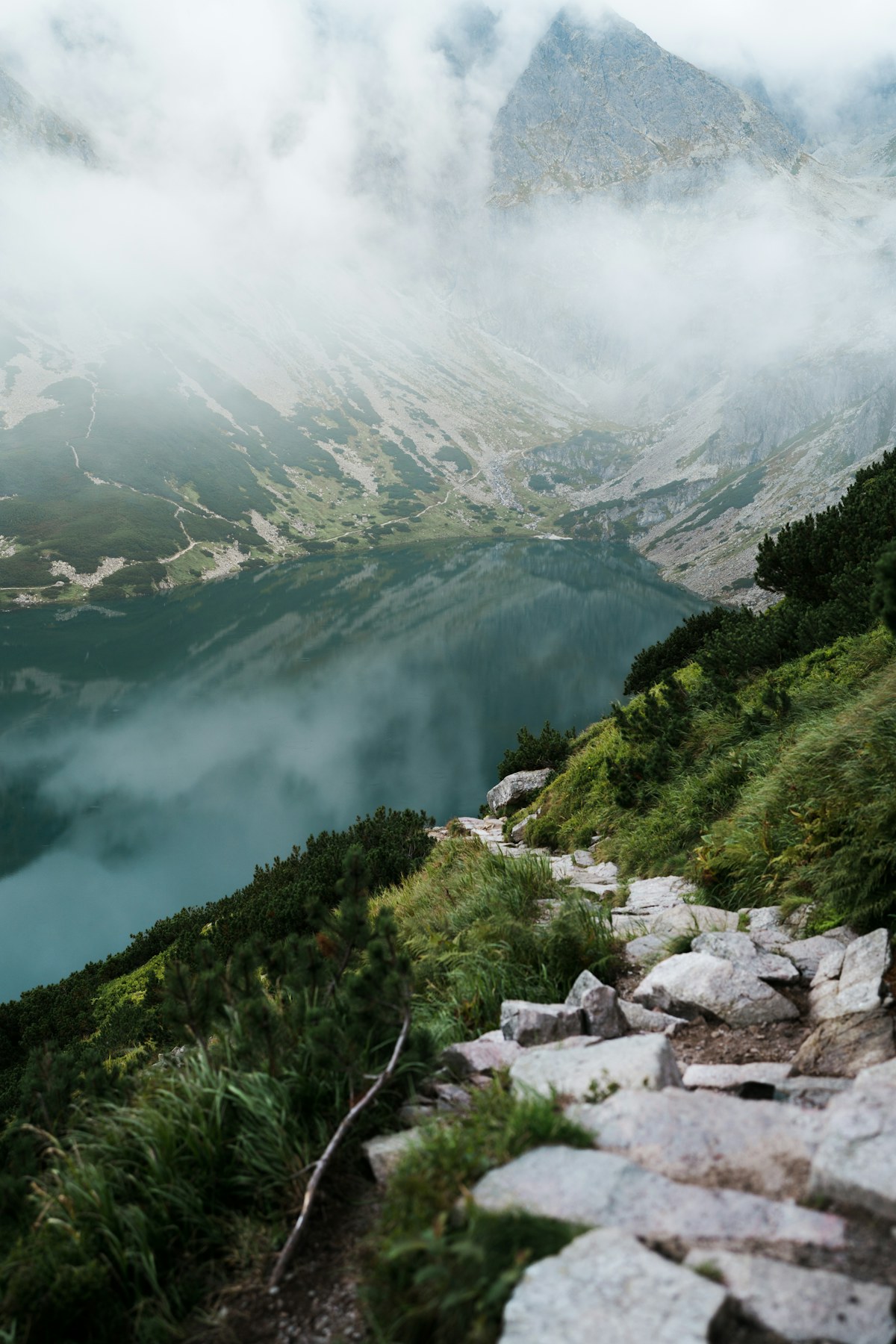 An alpine lake, stone trail and rocky peaks in the Tatras